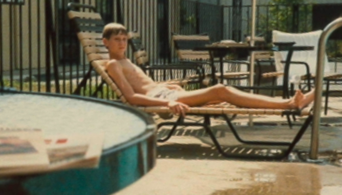 Treasurer Frerichs as a boy around 12 or 13, lounging in swimming trunks on a chaise lounge near a pool